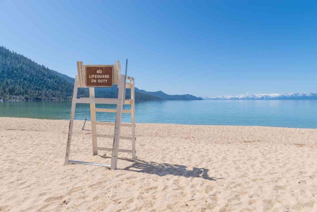 Empty lifeguard chair on a white sand beach in Lake Tahoe