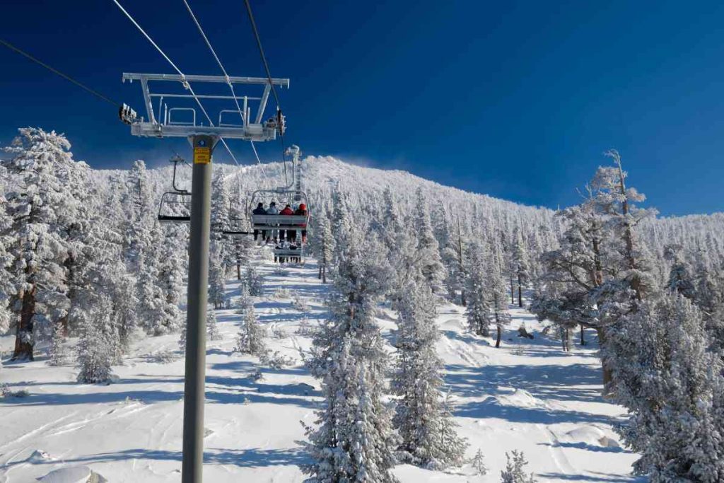 A ski lift over snowy trees in lake Tahoe.